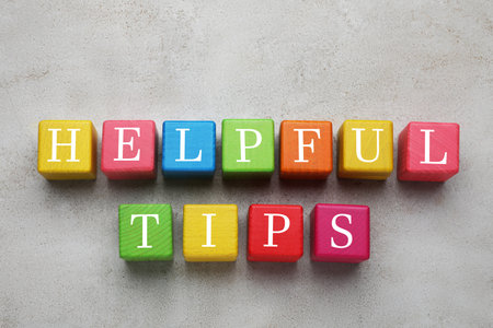 Text Helpful Tips made of colorful cubes with letters on gray table, top viewの写真素材