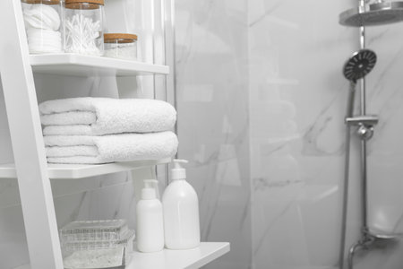 Stacked bath towels on white shelf in bathroom, space for textの写真素材