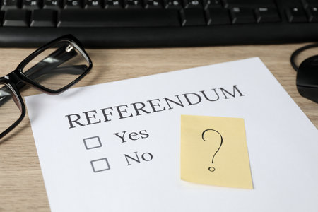 Referendum ballot, glasses and sticky note with question mark on wooden table, closeupの写真素材