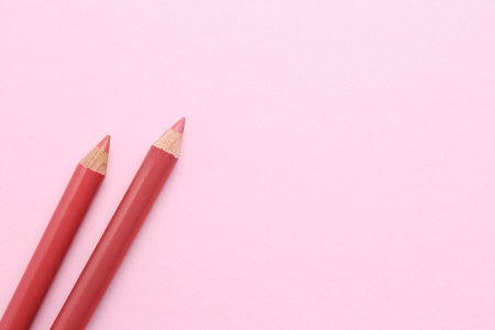 Lip pencils on pink background, flat lay with space for text. cosmetic productの写真素材