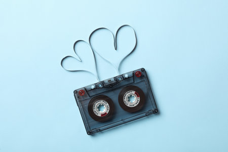 Music cassette and hearts made with tape on light blue background, top view. Listening love songの写真素材