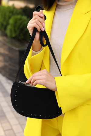 Fashionable woman with stylish bag on city street, closeupの写真素材