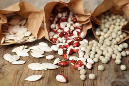 Different vegetable seeds on wooden table, closeupの写真素材