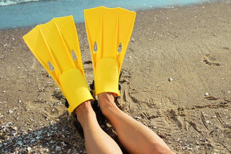 Woman in yellow flippers on beach, closeupの写真素材