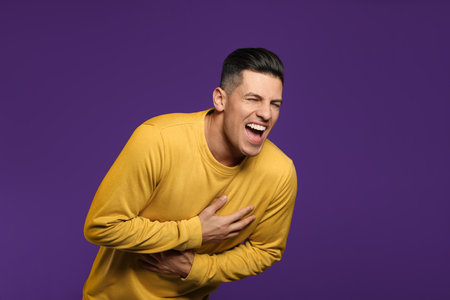 Handsome man laughing on purple background. funny jokeの写真素材