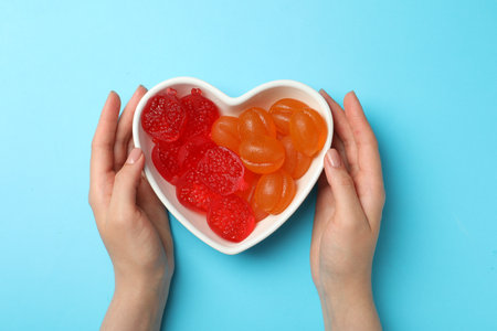 Woman with delicious gummy candies on light blue background, top viewの写真素材