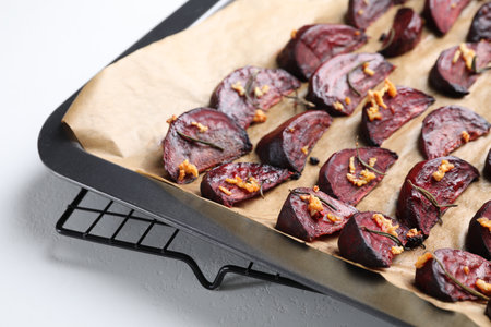 Baking tray with roasted beetroot slices on white table, closeupの写真素材