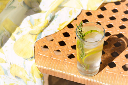 Tasty refreshing lemonade on wicker bench, space for text. summer drink