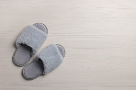 Pair of soft slippers on white wooden floor, top view. Space for textの写真素材