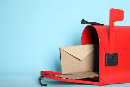 Open red letter box with envelopes on turquoise background, closeup. Space for textの写真素材
