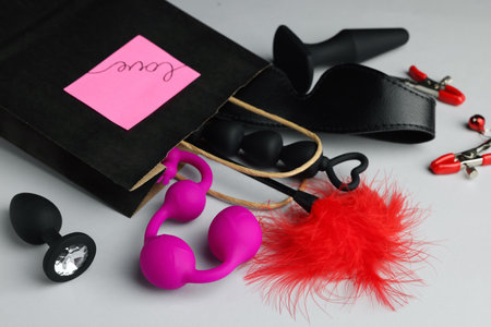 Paper shopping bag with different sex toys on white backgroundの写真素材