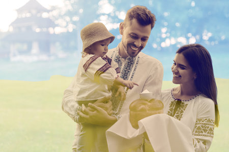 Double exposure of happy family wearing national clothes with bread and salt and Ukrainian flagの写真素材