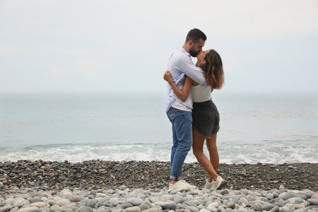 Young couple kissing on the beach near the sea. Space for textの写真素材