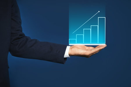 Salary increase concept. Man showing virtual image of charts and up arrow on blue background, closeupの写真素材