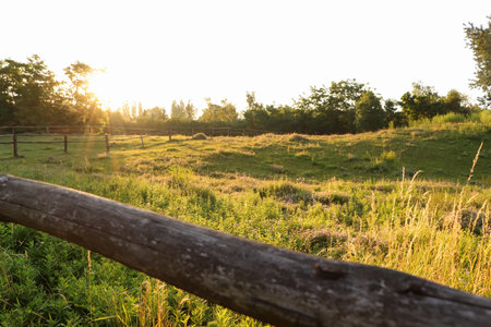 Picturesque view of the countryside with wooden fence in the morningの写真素材