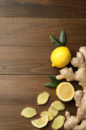 Fresh lemons and ginger on wooden table, flat lay. Space for textの写真素材
