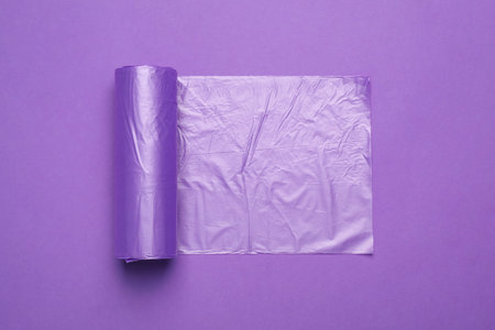 Roll of color garbage bags on violet background, top viewの写真素材