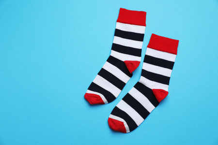 Striped socks on light blue background, flat lay. Space for textの写真素材