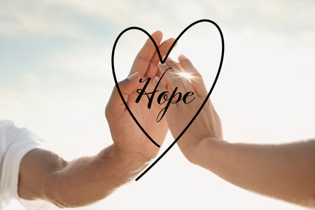 concept of hope. Man and woman reaching hands to each other, closeupの写真素材