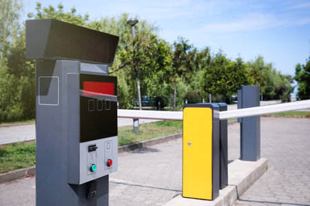 Modern road barriers and parking meter outdoors on sunny day