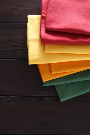 Different colorful napkins on wooden table, space for textの写真素材