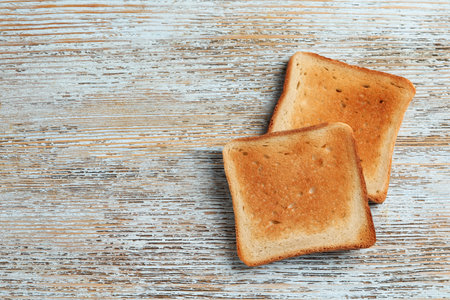 Slices of delicious toasted bread on wooden table, top view. Space for textの写真素材