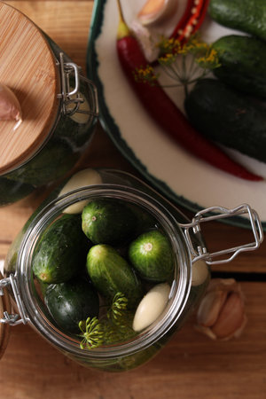 Jar with cucumbers, garlic and dill on wooden table, top view. pickling recipeの写真素材