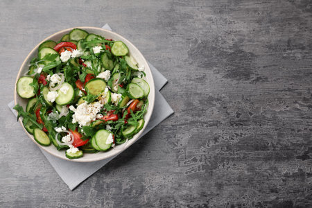 Plate of delicious cucumber salad on gray table, top view. Space for textの写真素材