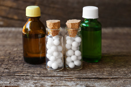 Bottles with homeopathic remedy on wooden stumpの写真素材
