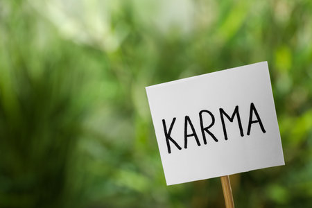 Sign with word Karma on blurred background, closeup. Space for textの写真素材