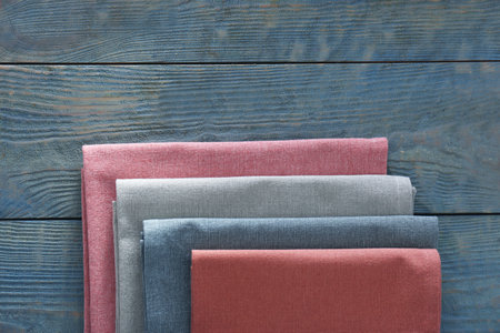 Different colorful napkins on wooden table, top view. Space for textの写真素材