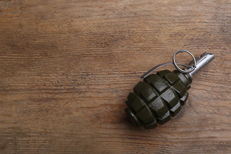 Hand grenade on wooden table, top view. Space for textの写真素材