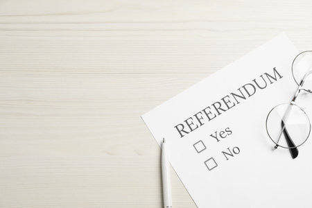 Referendum ballot with pen and glasses on white wooden table, flat lay. Space for textの写真素材