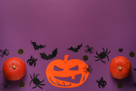 Flat lay composition with pumpkins, paper bats and spiders on purple background, space for text. halloween celebrationの写真素材