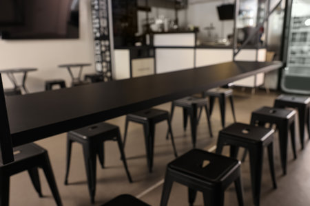 Blurred view of hostel dining room interior with comfortable furniture and coffee shop