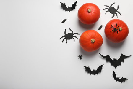 Flat lay composition with pumpkins, paper bats and spiders on white background, space for text. halloween celebrationの写真素材