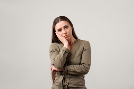 Portrait of young woman on light gray background. Personality concept