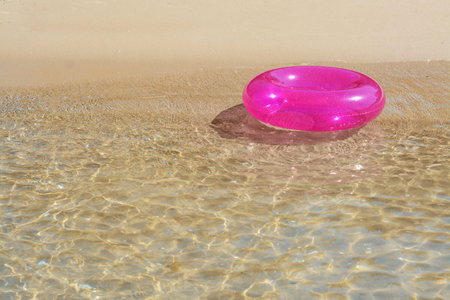 Bright inflatable ring floating on sea water. Space for textの写真素材