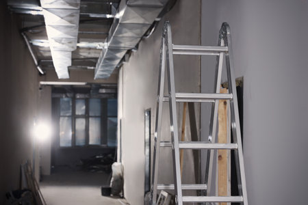 Metal ladder and building materials in hall prepared for renovationの写真素材