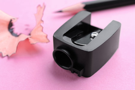 Pencil sharpener and shavings on pale pink background, closeupの写真素材