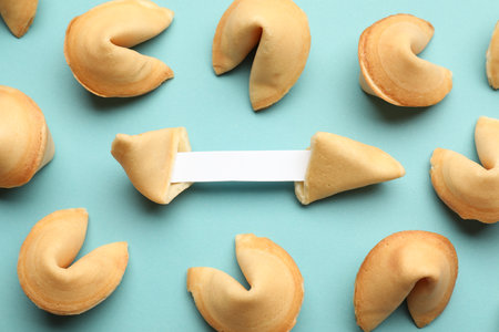 Tasty fortune cookies with predictions on light blue background, above view. Space for textの写真素材