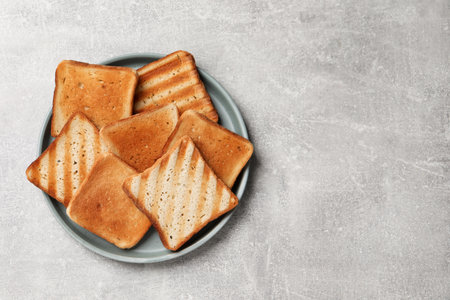 Slices of tasty toasted bread on light gray table, top view. Space for text