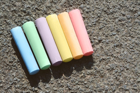 Colorful chalk sticks on asphalt, flat lay. Space for textの写真素材
