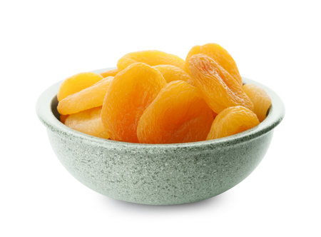 Ceramic bowl with tasty dried apricots isolated on whiteの写真素材