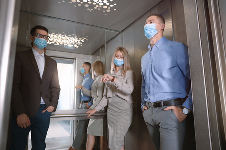 Group of people with face masks in elevator. protective measures