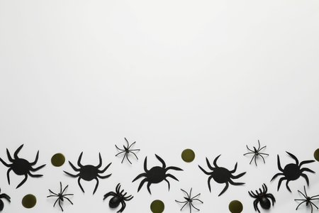 Flat lay composition with spiders and golden confetti on white background, space for text. halloween celebrationの写真素材