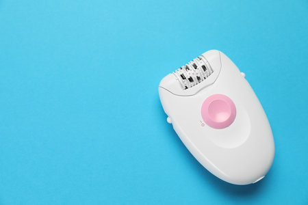 Modern epilator on light blue background, top view. Space for textの写真素材