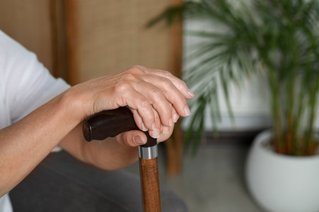 Elderly woman with walking cane indoors, closeup. home care service