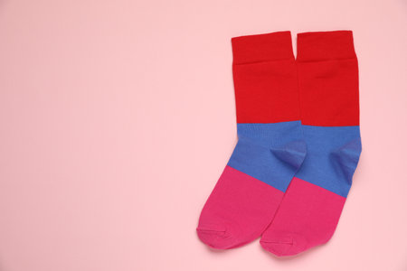 Striped socks on pink background, flat lay. Space for textの写真素材