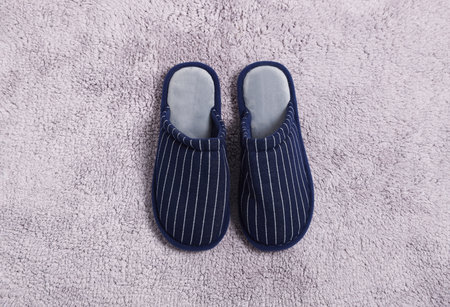 Pair of stylish slippers on light gray carpet, top view